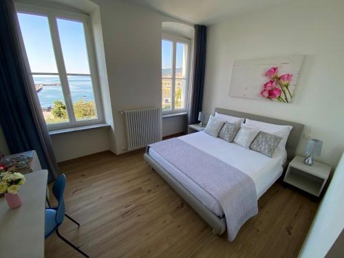 a bedroom with a bed and two windows at Five Flowers - Guest House in Trieste