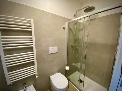 a bathroom with a toilet and a glass shower at Five Flowers Guest House in Trieste