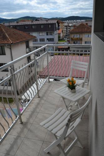 a balcony with two chairs and a table with flowers on it at Galtex in Pale