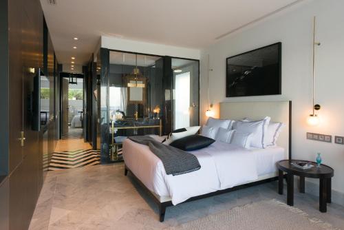 a bedroom with a large white bed and a bathroom at Maison Dedine- SmallLuxuryHotels -Adults Only in Sidi Bou Saïd