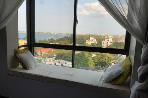 - un siège de fenêtre dans une chambre avec vue dans l'établissement Grany Apartment - Palm Village, à Dar es Salaam