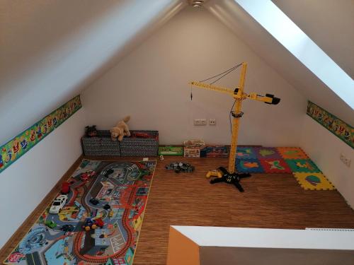 a attic room with a bed and toys on the floor at JOE APARTMAN in Kőszeg