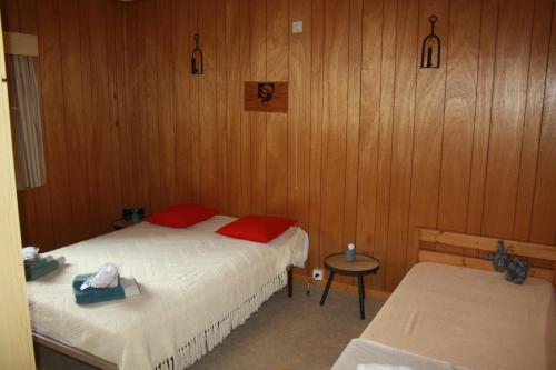a bedroom with two beds and a small table with a table at Le Piroy in Saint-Hubert