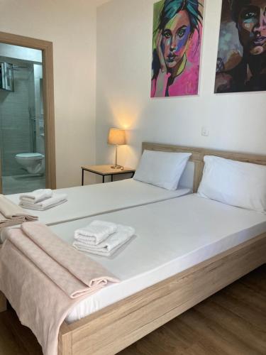 a bedroom with a large white bed with towels on it at Apartments Mrdak in Bar