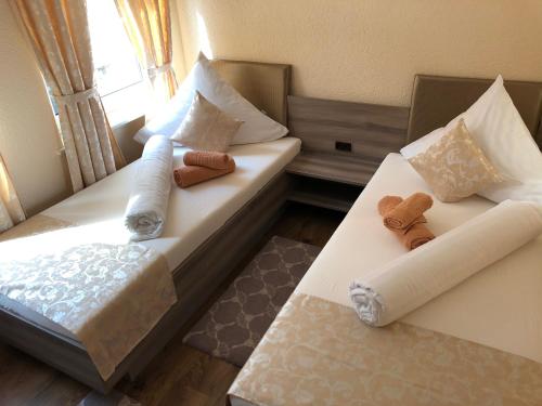 two beds in a room with towels and teddy bears at Pension Goldenes Vogtland in Adorf