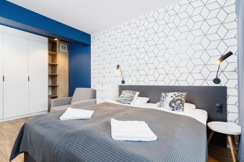 sypialnia z łóżkiem i niebiesko-białą ścianą w obiekcie Apartamenty 3d Wilga by Renters w Krakowie