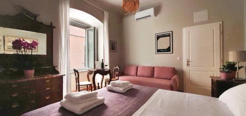 a bedroom with a bed and a pink couch at Muziqa Apartments in Dubrovnik