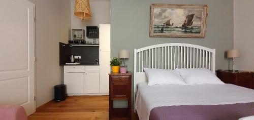 a bedroom with a white bed and a kitchen at Muziqa Apartments in Dubrovnik