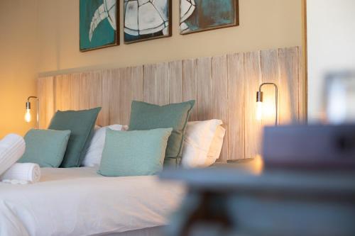 a bedroom with a bed with green and white pillows at iLanga Lodge in St Lucia