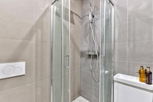 une douche avec une porte vitrée dans une salle de bain dans l'établissement 117 - Urban C'est La Vie in Montorgueil, à Paris
