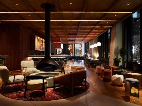 a lobby with a fireplace and chairs and tables at THE KNOT SAPPORO in Sapporo