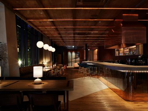 a restaurant with a bar with tables and chairs at THE KNOT SAPPORO in Sapporo