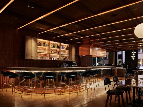a bar in a restaurant with chairs and tables at THE KNOT SAPPORO in Sapporo