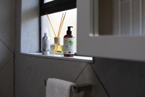 a bathroom with a shelf with alcohol bottles and a mirror at iLanga Lodge in St Lucia