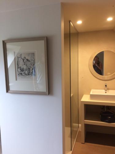 een badkamer met een wastafel en een spiegel bij La Maison d'Arc Chambres et Tables d'Hôtes in Frasnes-lez-Anvaing