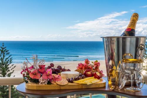 a table with a bottle of champagne and a plate of food at Eden Tower in Gold Coast