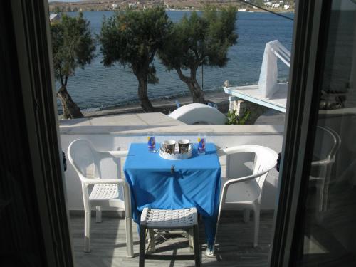 a table with a blue table cloth on a balcony at Alexandra's Rooms in Parikia