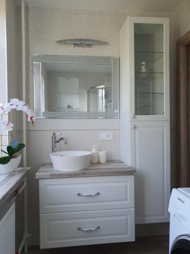 bagno con lavandino bianco e specchio di Marijampolės jaukūs apartamentai a Marijampolė