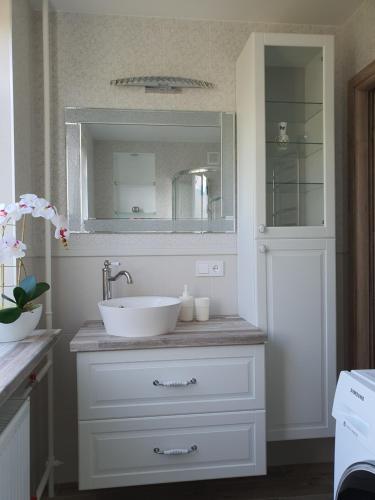a bathroom with a white sink and a mirror at Marijampolės jaukūs apartamentai in Marijampolė