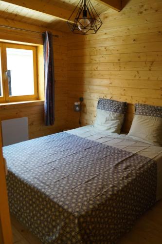 a bedroom with a bed in a wooden room at chalet audruicquois in Audruicq