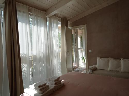 a bedroom with a bed and a window with towels on it at La Casa di Tara B&B Armonia e Natura in Recanati