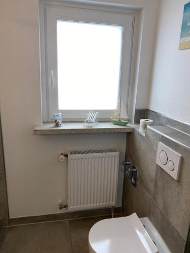 a bathroom with a white toilet and a window at Apartments Benzweg 2 in Northeim