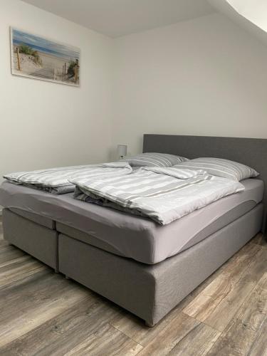 a bed in a bedroom with a wooden floor at Apartments Benzweg 2 in Northeim