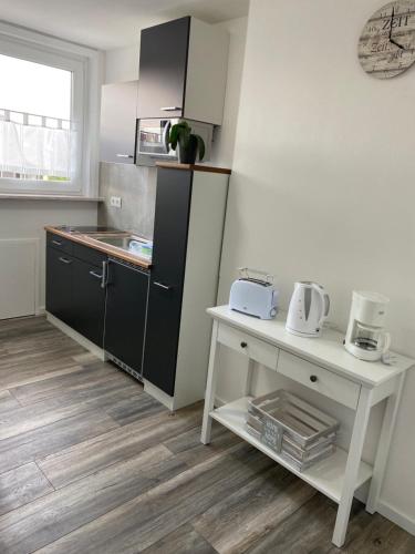a kitchen with black cabinets and a white counter at Apartments Benzweg 2 in Northeim