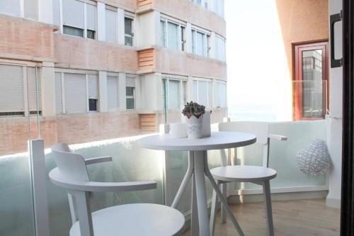 einen Tisch und zwei Stühle in einem Zimmer mit Fenster in der Unterkunft VV Loft Canteras Gran Playa "by henrypole home" in Las Palmas de Gran Canaria