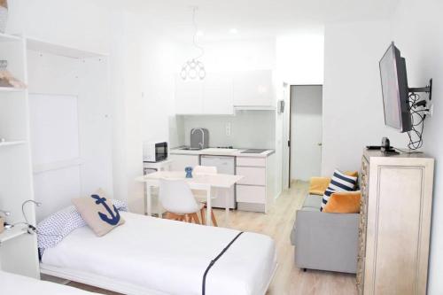 a white room with a bed and a kitchen at VV Loft Canteras Gran Playa "by henrypole home" in Las Palmas de Gran Canaria