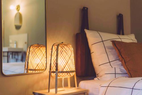a bedroom with a bed with a mirror and a lamp at EDELFUCHS-LODGE in Bühlertal