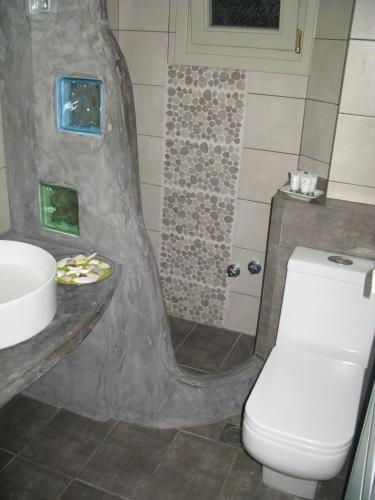 a bathroom with a toilet and a sink at Alexandra's Rooms in Parikia