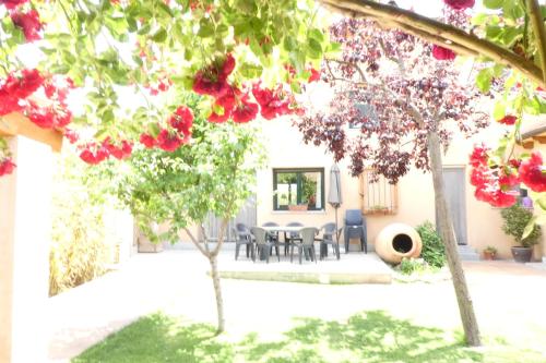 a garden with a table and chairs and red flowers at Casa del Portalón in Ituero y Lama