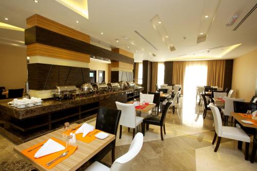 une salle à manger avec des tables et des chaises dans un restaurant dans l'établissement Nehal Hotel, à Abu Dhabi