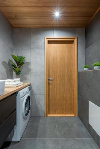 a wooden door in a laundry room with a washing machine at TartuKodu Riia 20B-3 in Tartu