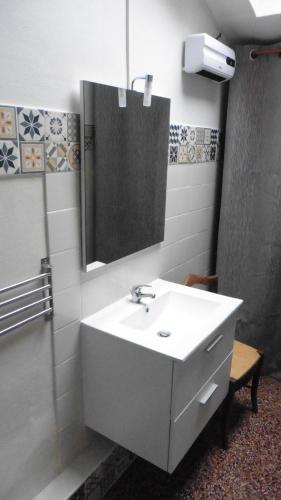 a bathroom with a white sink and a mirror at L'arbrissel in Fontevraud-l'Abbaye