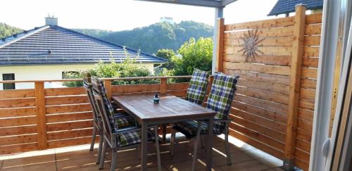 a wooden table and chairs on a balcony at Ferienhaus Gradaus in Riedenburg