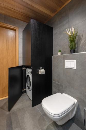 a bathroom with a washing machine and a toilet at TartuKodu Riia 20B-13 in Tartu