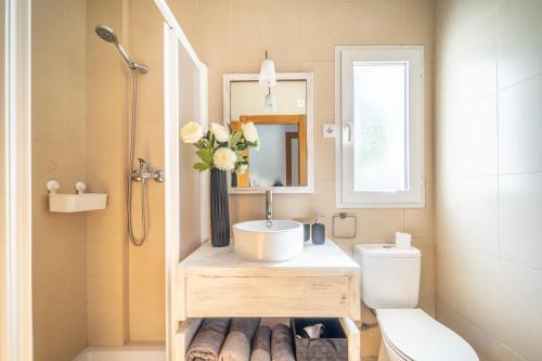 a bathroom with a sink and a toilet and a mirror at Villa mit privatem Pool, zentrumsnah in Roldán