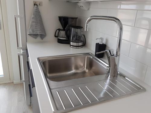 a stainless steel sink in a white kitchen at New studio in West-Pasila in Helsinki