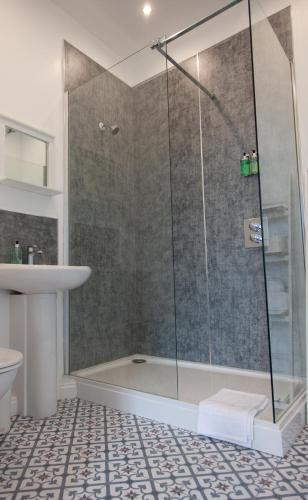 ein Badezimmer mit Dusche und Waschbecken in der Unterkunft Coorie in Dunfermline