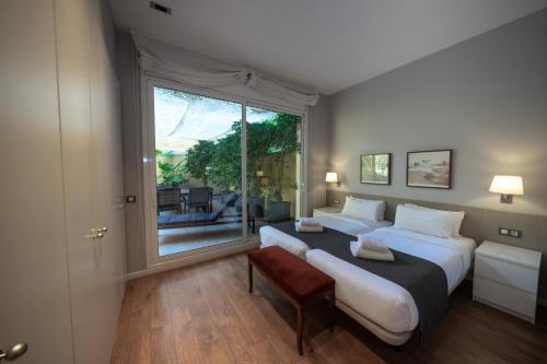 1 dormitorio con 2 camas y ventana grande en Bonavista Apartments - Passeig de Gracia, en Barcelona