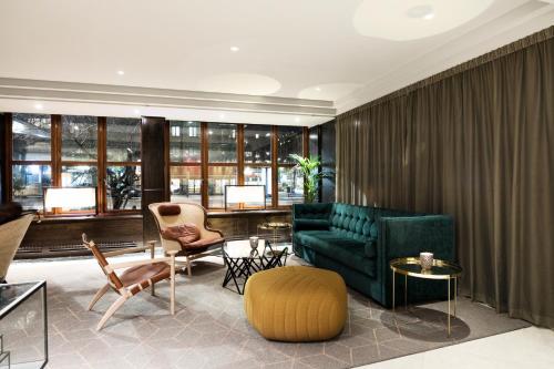 a living room with a green couch and chairs at Elite Park Avenue Hotel in Gothenburg