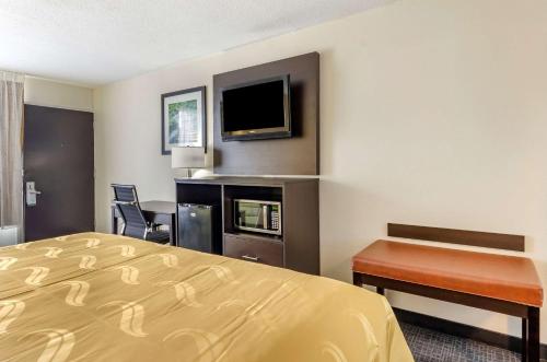 a hotel room with a bed and a desk and a tv at Quality Inn Verona - Staunton North in Staunton