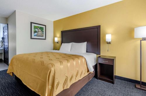 a large bed in a hotel room with yellow walls at Quality Inn Verona - Staunton North in Staunton