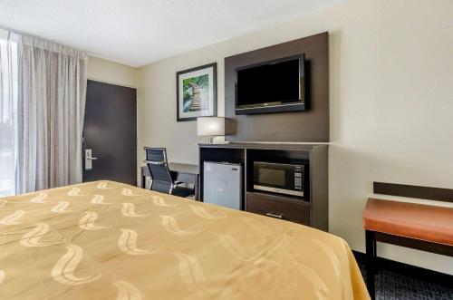 a hotel room with a bed and a flat screen tv at Quality Inn Verona - Staunton North in Staunton
