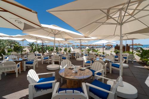 a restaurant with white chairs and tables and umbrellas at MS Amaragua in Torremolinos