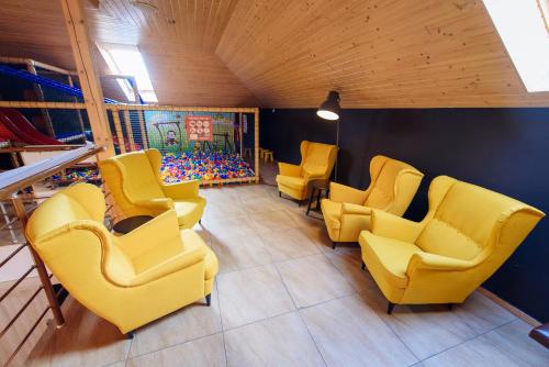 a waiting room with yellow chairs and a painting at Turciansky dvor - Apartmany Turiec in Martin