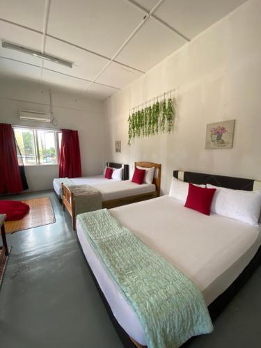 a hotel room with two beds and a couch at Motel Pantai Cahaya in Port Dickson