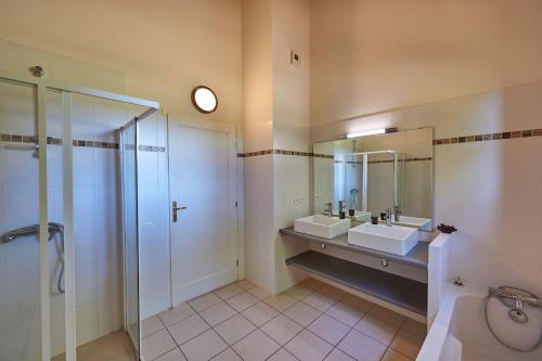 a large bathroom with two sinks and a shower at Résidence Château de Salles in Salles